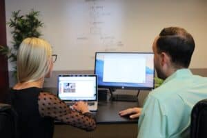 Efficient supply chain management with China Vast Logistics, showcasing professionals analyzing shipping data on a laptop and desktop monitor for global logistics solutions.