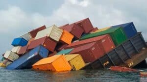 Shipping containers tipping over in water, showcasing logistics and freight transportation challenges.
