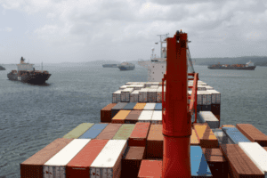 Container cargo ship with stacked containers at sea, logistics, shipping, international freight, China Vast Logistics, maritime transport, freight forwarding, port operations, global supply chain.