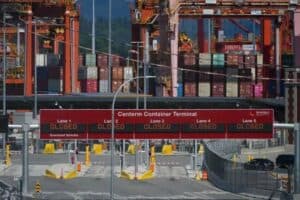 Centerm Container Terminal with multiple closed lanes, cargo containers, and cranes in the background, highlighting port disruption or shutdown