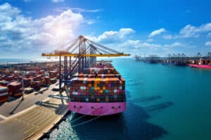 Large cargo ship at China Vast Logistics port with stacked shipping containers and cranes, showcasing international freight, shipping, and logistics services in China.