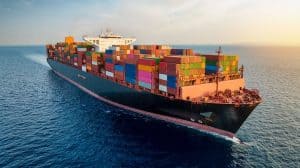 Large cargo ship with colorful containers sailing in open sea, representing global logistics and freight transport.