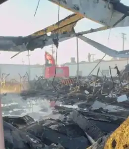 Collapsed building destruction and rescue operation after fire in China Vast Logistics facility. Emergency responders working amidst debris at the site of structural damage.