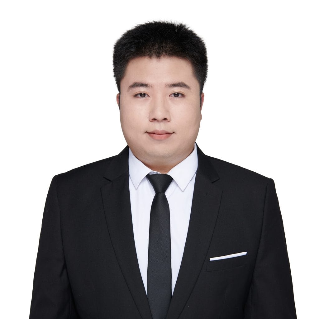 Professional headshot of Lyndon, sales representative at Vastlog, wearing a black suit and tie with a white shirt, posed against a plain background