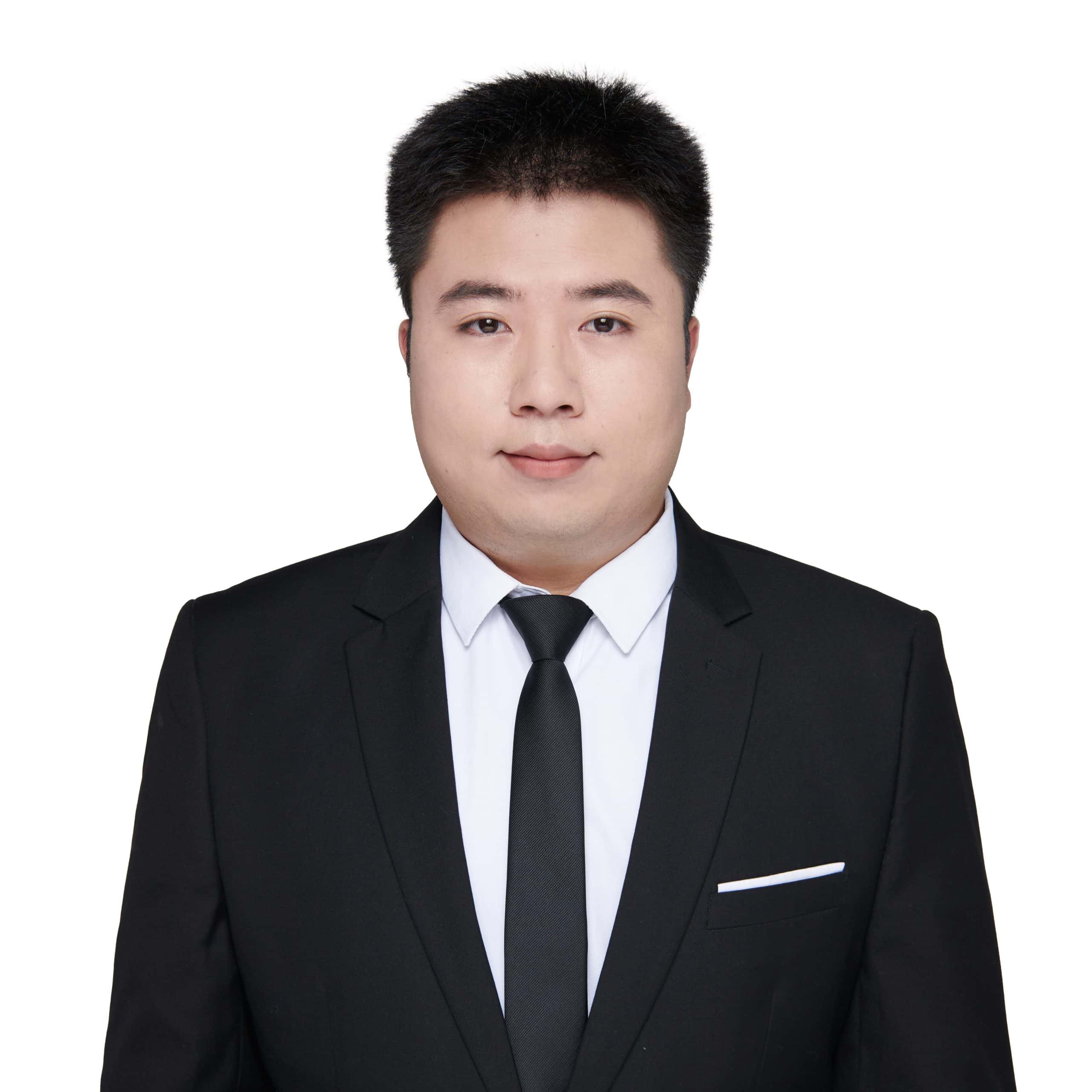 Professional headshot of Lyndon, sales representative at Vastlog, wearing a black suit and tie with a white shirt, posed against a plain background