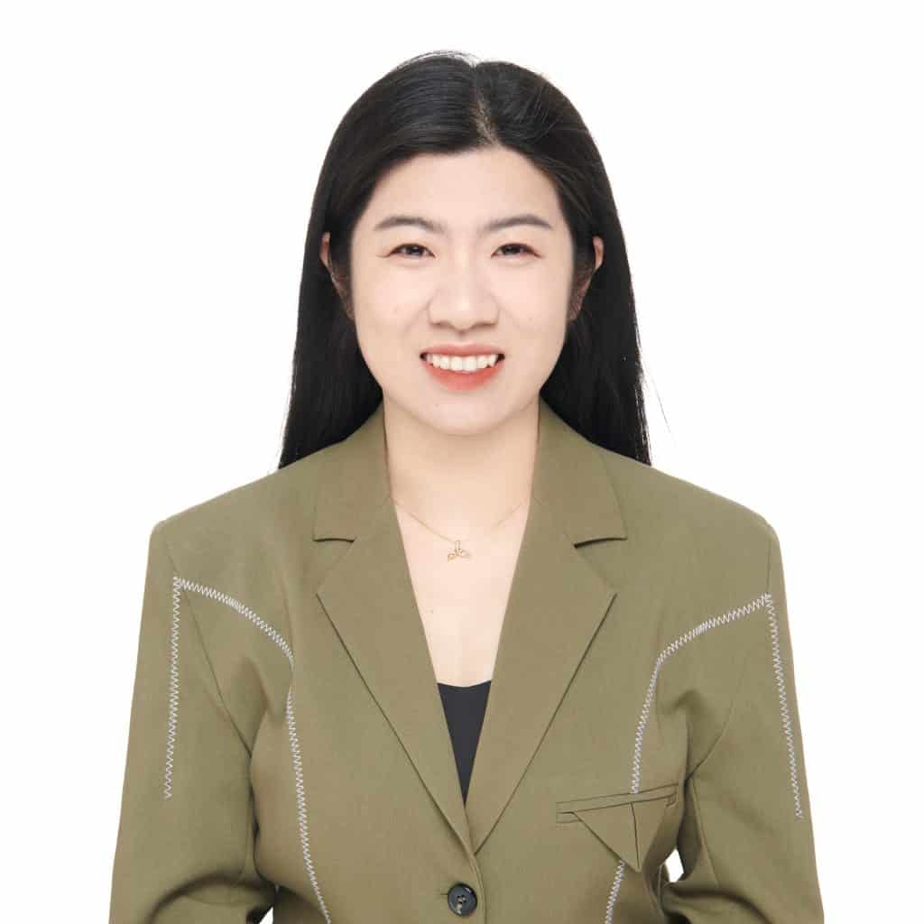 Professional headshot of Jessy, sales representative at Vastlog, wearing an olive green blazer and black top, smiling against a plain background