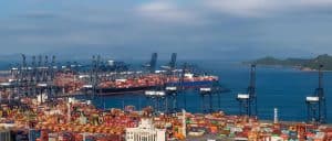 Container port with cranes and cargo ships at China Vast Logistics hub, specializing in international shipping and freight forwarding.