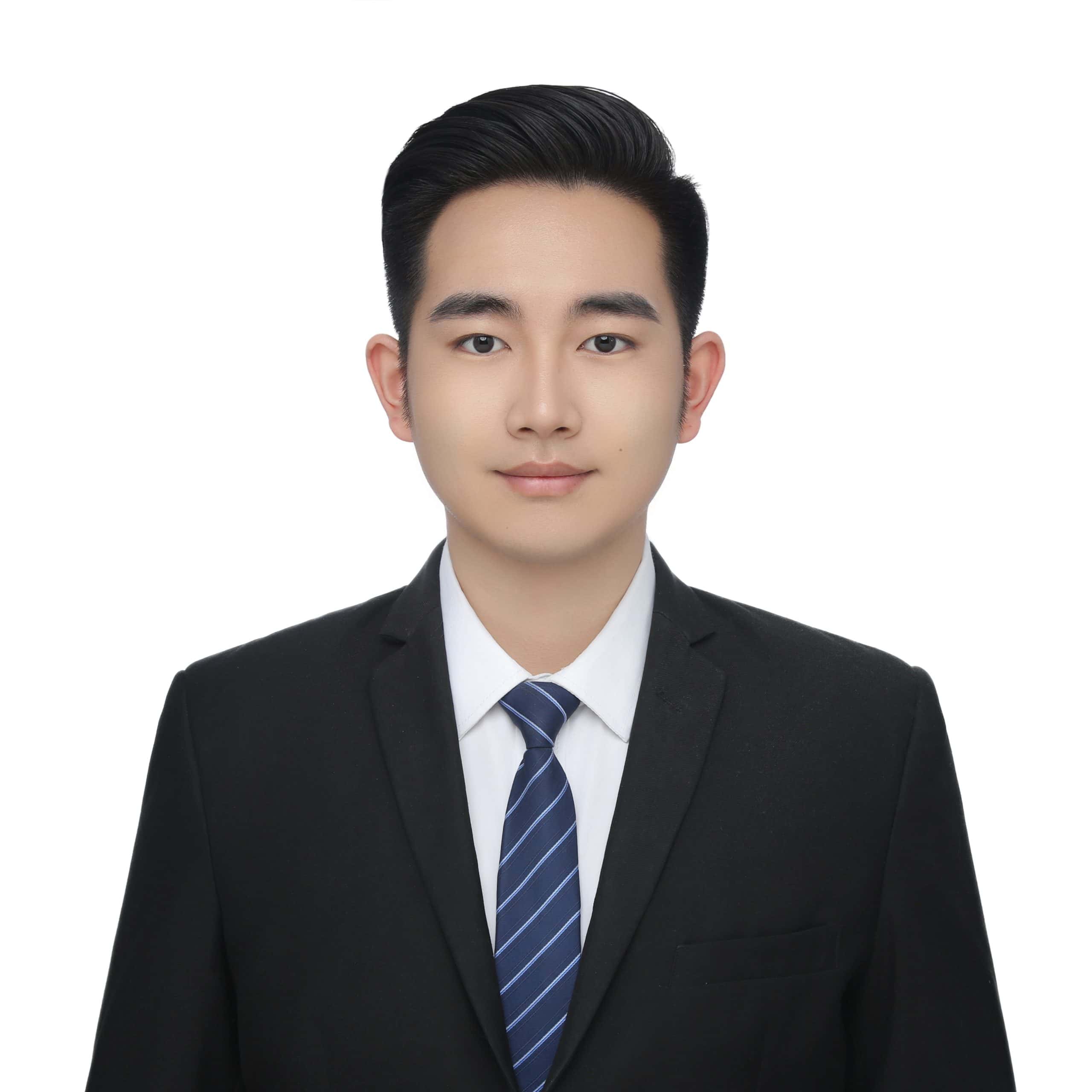 Professional headshot of Ryan Ren, sales representative at Vastlog, wearing a black suit, white shirt, and striped tie, posed against a plain background