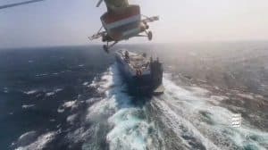 Cargo ship escorted through Suez Canal, aerial view with helicopter maritime operations