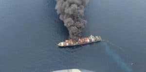 Container ship on fire at sea, vessel explosion and maritime emergency response