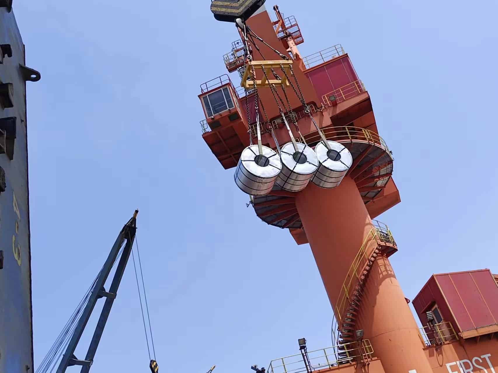 Steel coils loading at Qingdao Port, crane operation for bulk cargo handling in international shipping