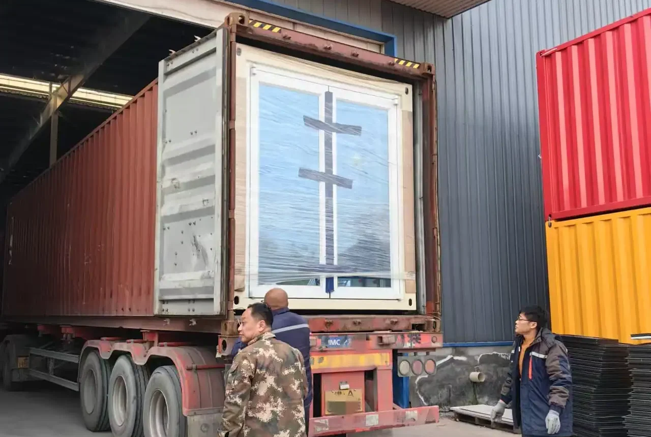 工人现场监督装柜操作，集装箱货物装载进卡车车厢
